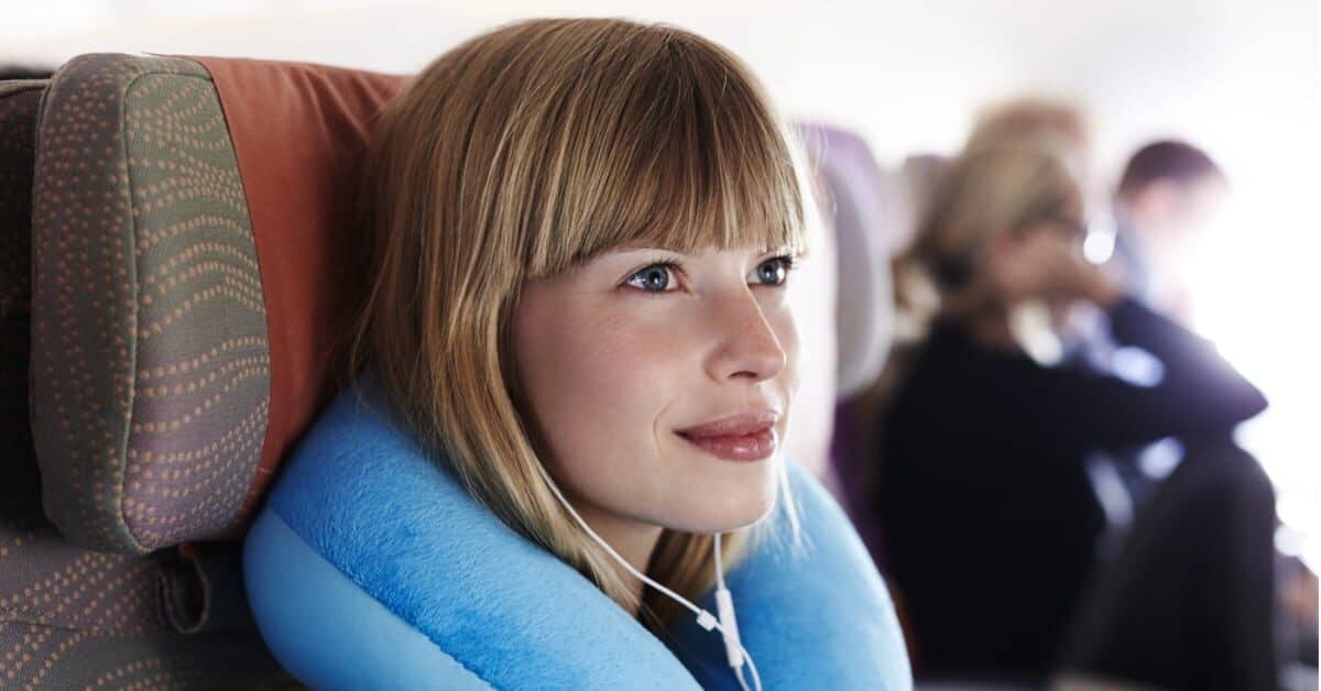 Woman with neck pillow on plane